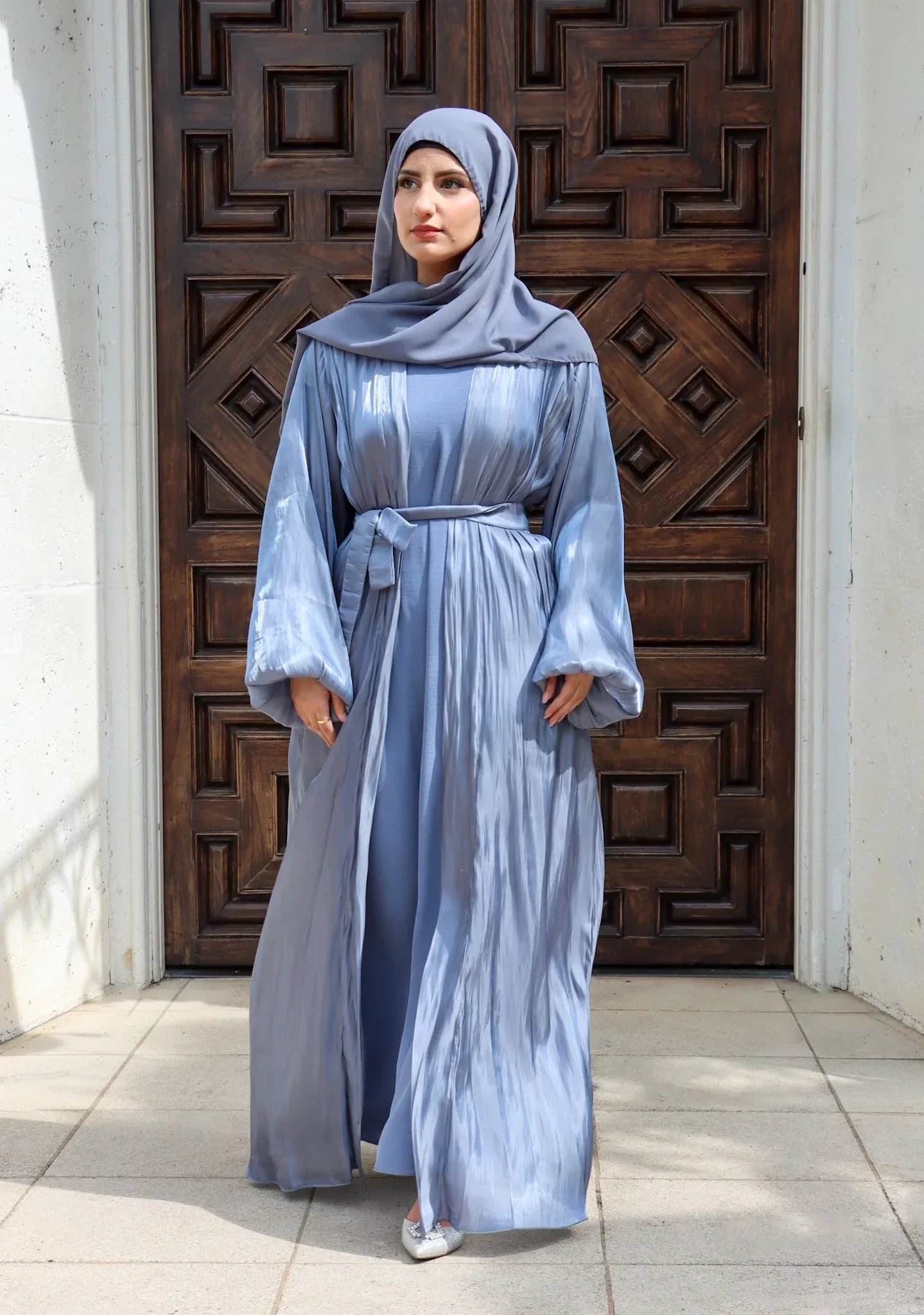 Elegant satin abaya set with flowing silhouette and balloon sleeves. Premium fabric delivers a luxurious drape while maintaining modest coverage. Perfect for special occasions or everyday sophistication.