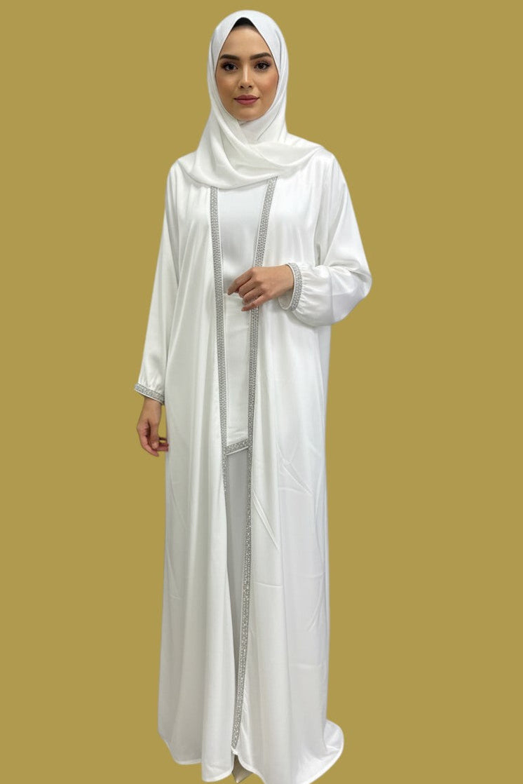 Model wearing a white Shuto Modest Boutique Deena Elegant Abaya 4-piece silk set with silver embellished trim.